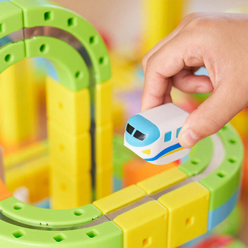 Rainbow magnetic track pieces assembled into a loop with the electric track car on it