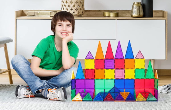 a young boy playing with the magnetic building blocks